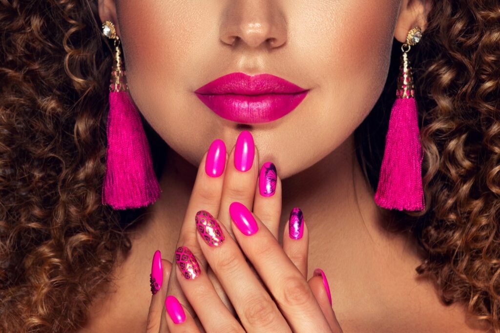 Fashion model with hot pink nail polish and brightly colored makeup