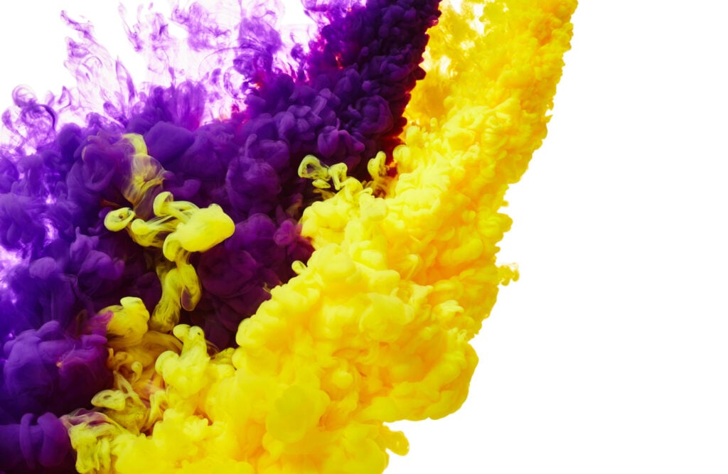 Yellow and purple ink drop in water.