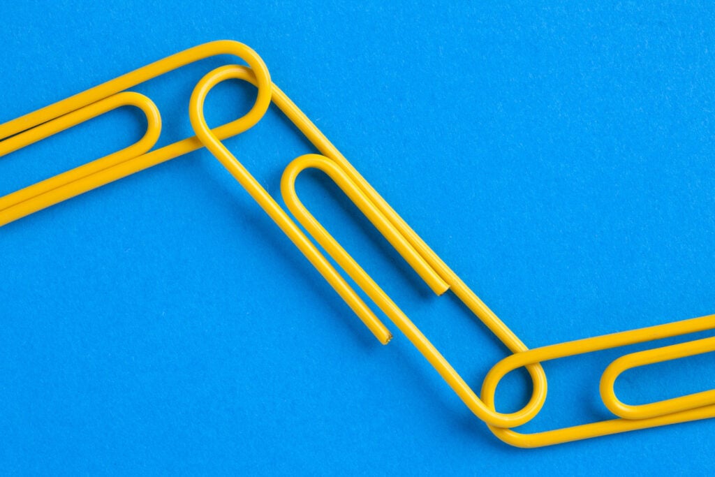 Close-up image of yellow paperclips connected to each other.