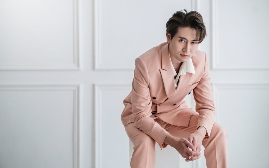 Asian guy sitting in a pink suit