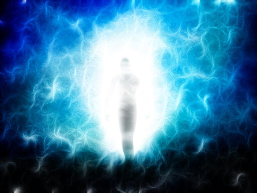  Illustration of a person with a glowing aura standing in a blue, ethereal mist.