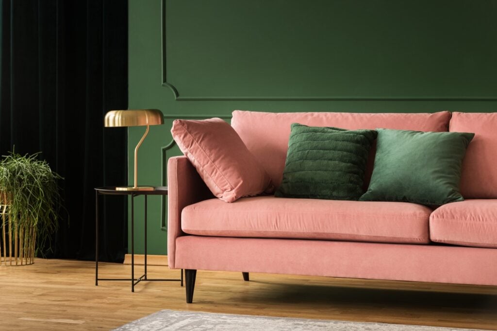Pink velvet sofa in green living room