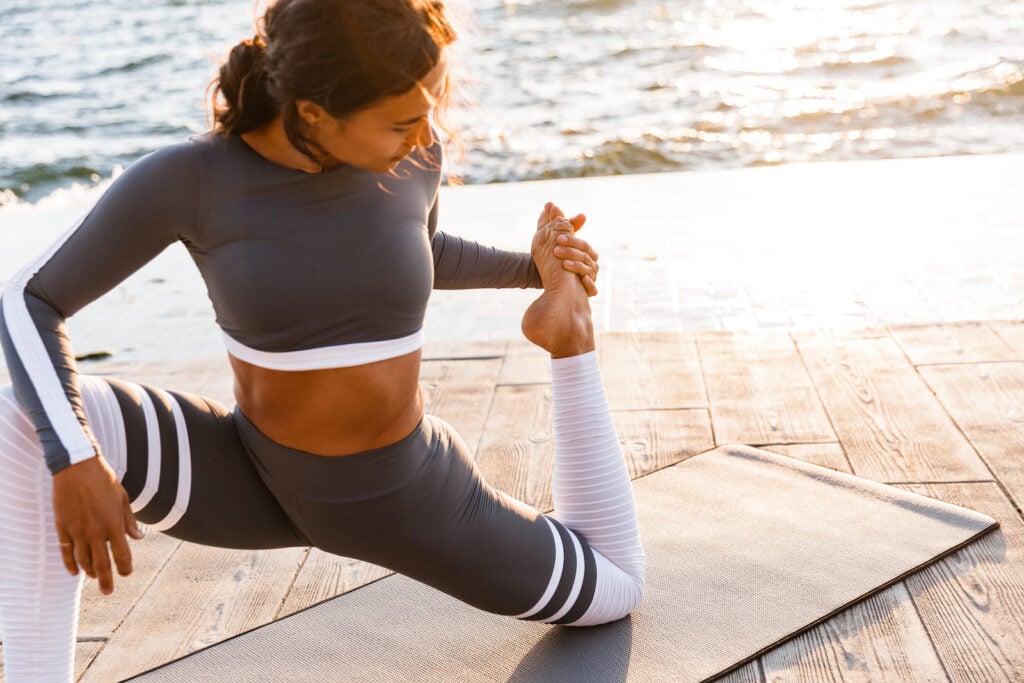 Woman outdoors near the beach doing yoga.