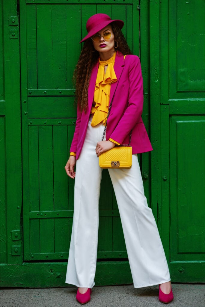 Outdoor full body portrait of young woman wearing colorful clothes.