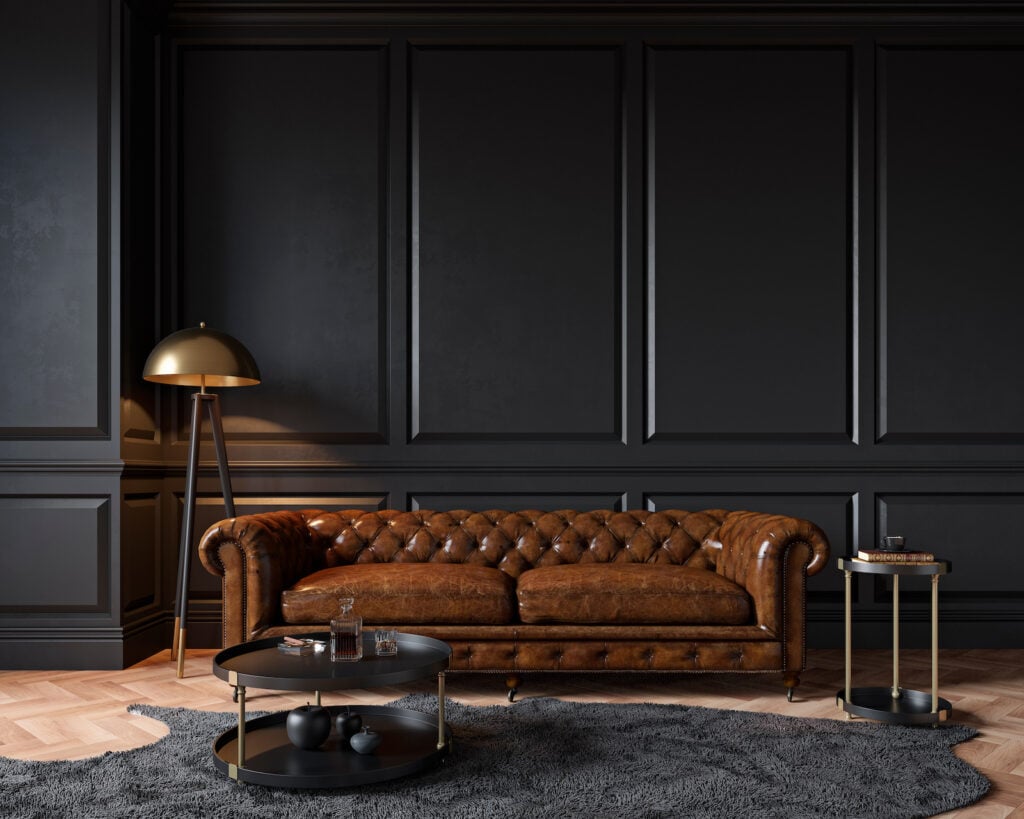 Modern classic black interior with capitone brown leather chester sofa.