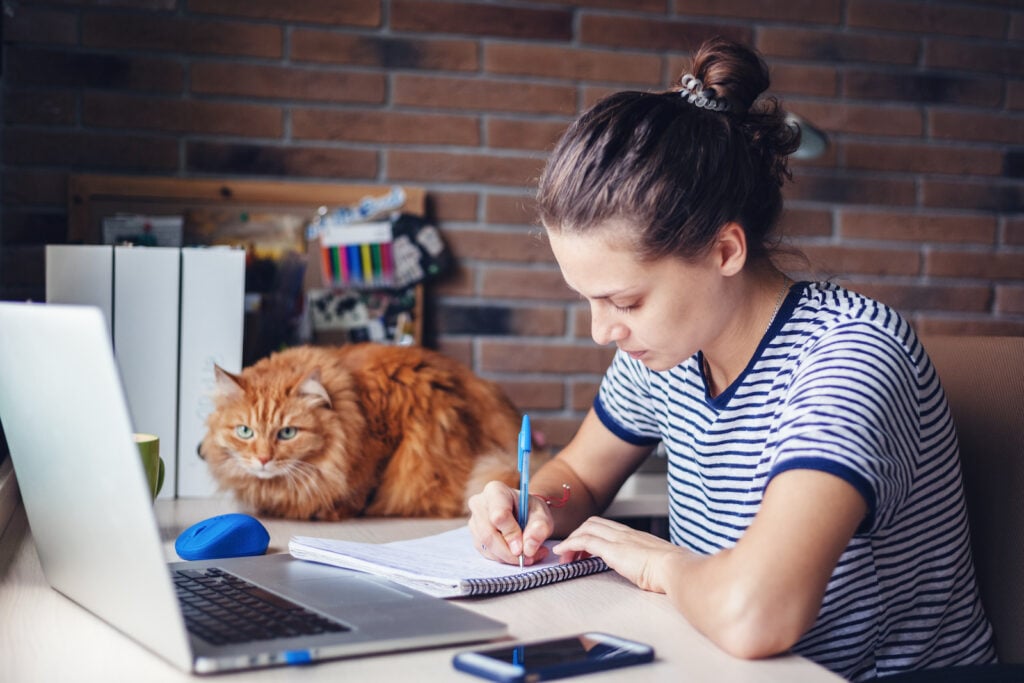 Woman working in office with brick walls.