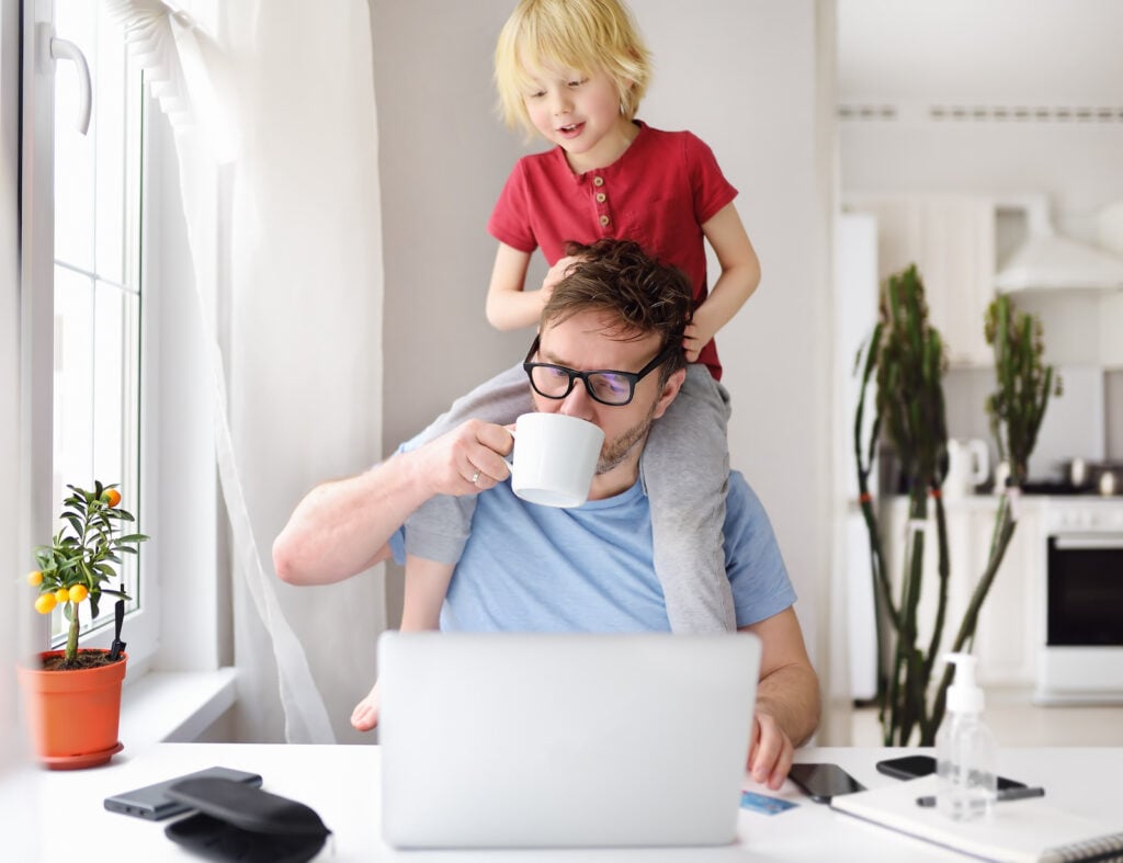 Man sitting in Cool White office with child on his shoulders.