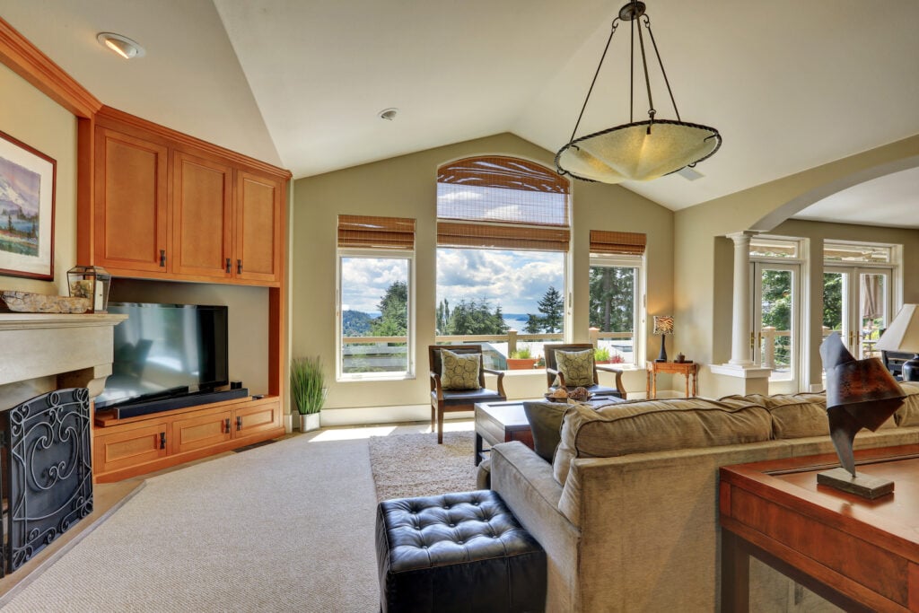 Vaulted ceiling living room with large windows overlooking beautiful view.