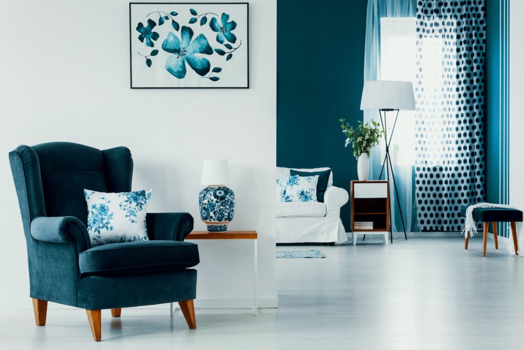 Fashionable living room with comfortable dark blue armchair with pillow.