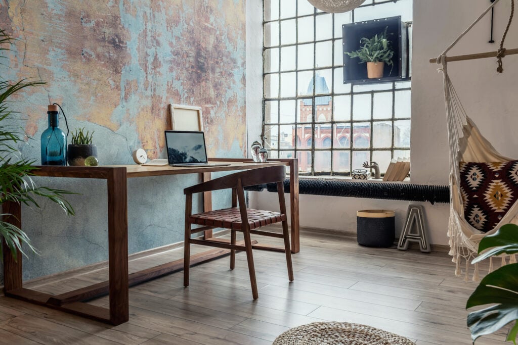 Stylish interior design of office space in loft apartment with wooden desk.