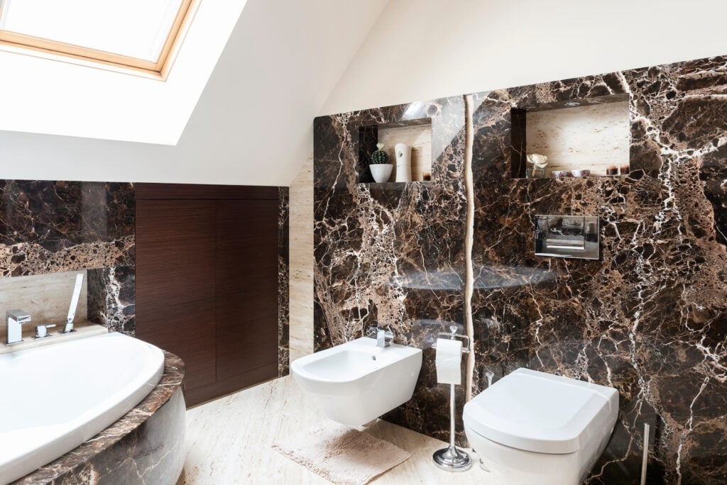 Luxury interior of bathroom with black-brown marble walls.