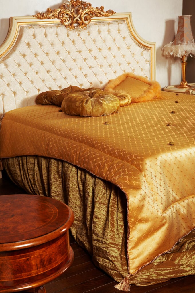 Stylish double bed with gold headboard and mattress.