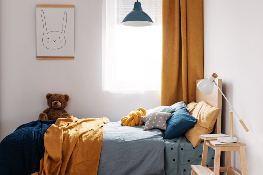 Kid's bedroom with mustard yellow curtains.