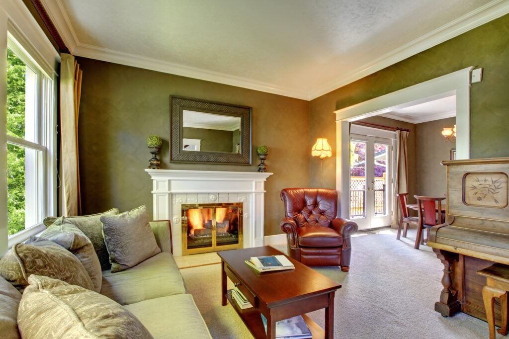 Elegant classic green living room with fireplace and piano.