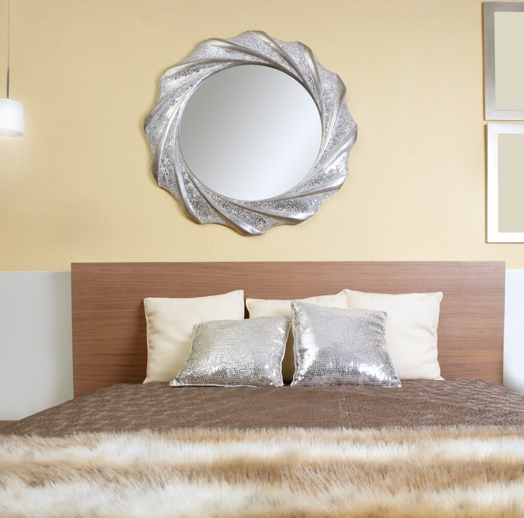 Bedroom with silver pillows and wall hangings.