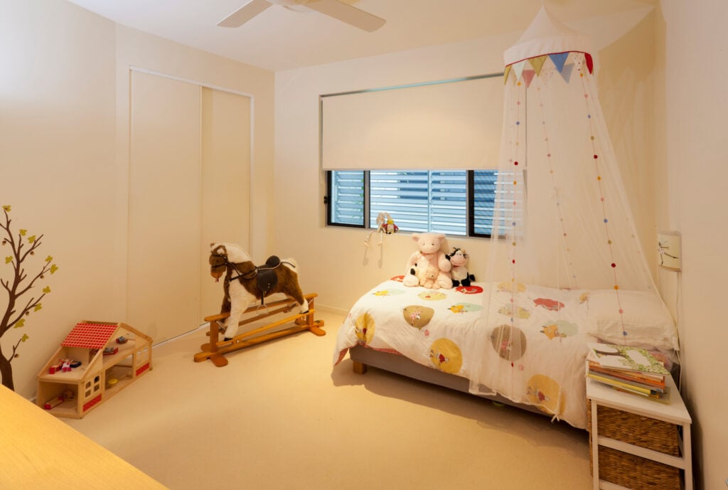 Little girl's bedroom with warm white walls.