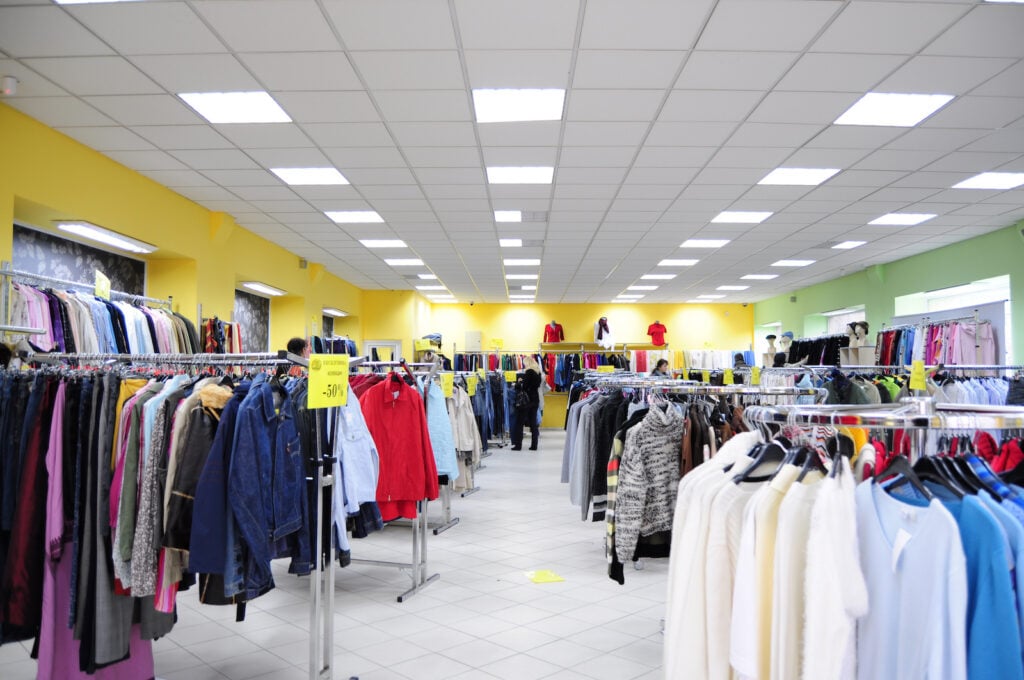 Interior of thrift store with yellow wall and discount signs