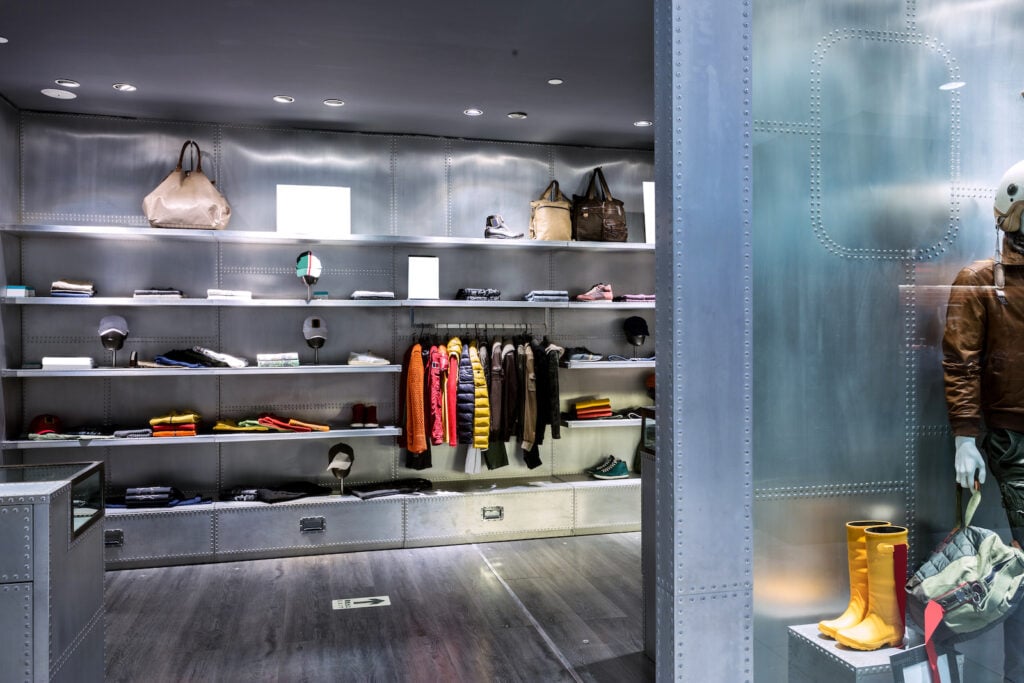 Interior of boutique clothing store with silver steel walls and shelving