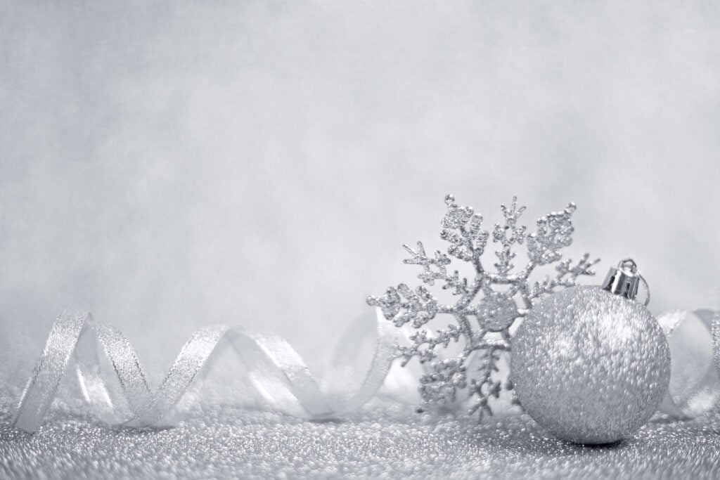 A glittery silver Christmas ornament with ribbon and silver snowflake decoration