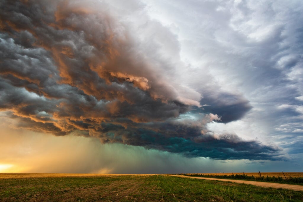 Storm clouds with a slight green tint float over a field
