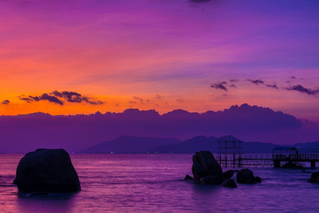 A brilliant pink, purple, and orange sky over water