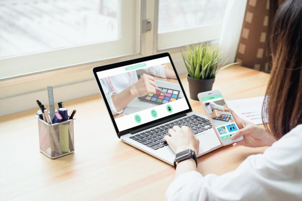 A web designer focuses on programs both on her computer and phone