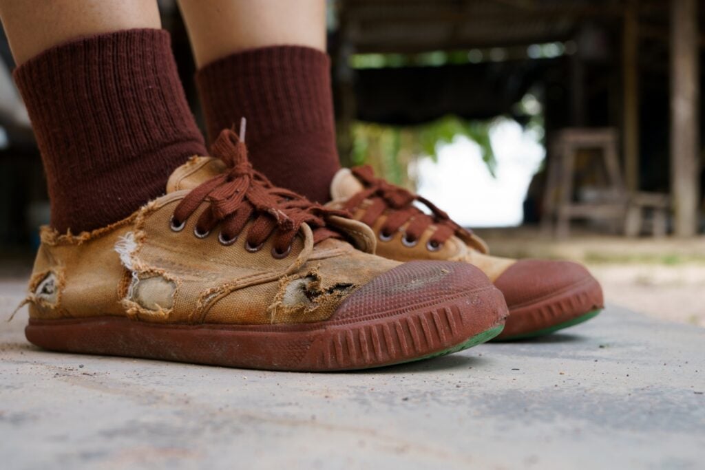 Ripped brown shoes with darker brown socks