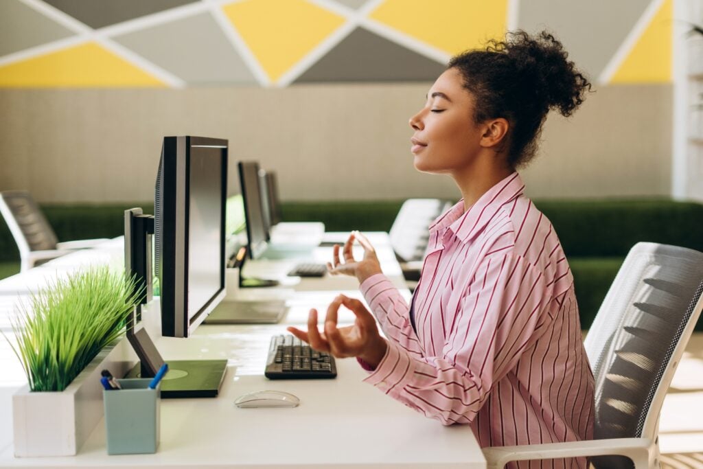 Person meditating at office desk