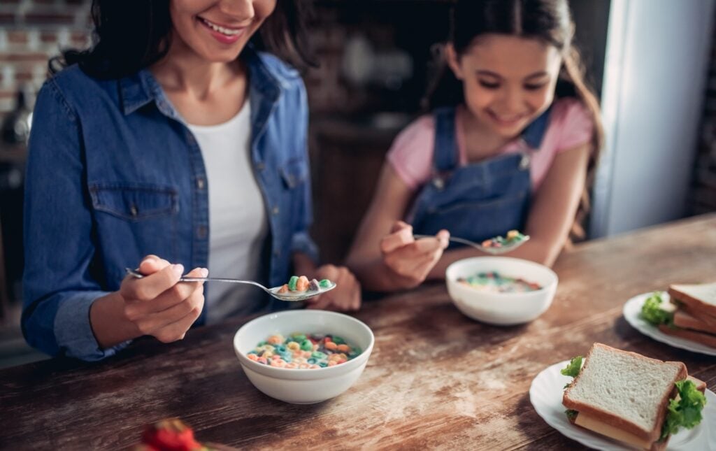 Mother and daughter eating colorful cereal