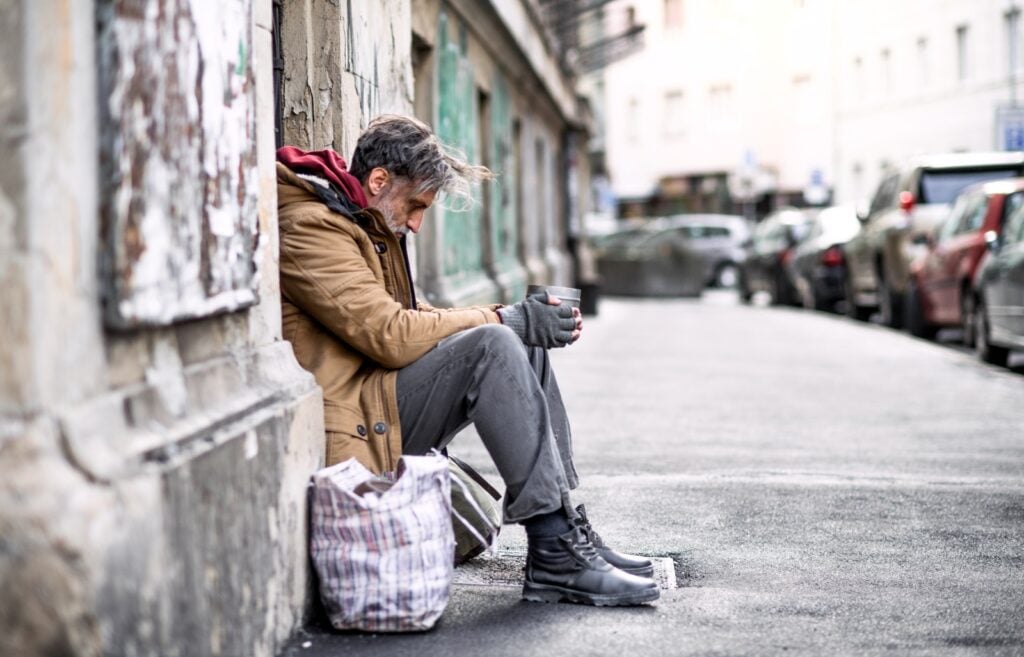 Homeless man wearing gray pants