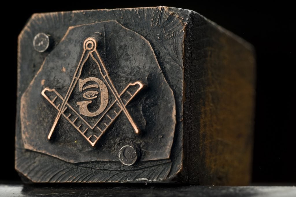 Freemasonry symbol on a slightly burnt wooden post