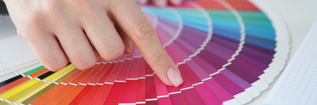 Designer selecting colors by pointing finger at color swatch