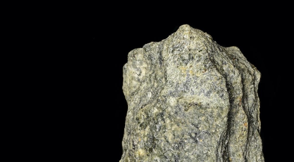 Greenstone is an igneous rock that, as the name suggests, is often green in color. However, it also can sometimes appear with dark gray or gray-green coloring.
