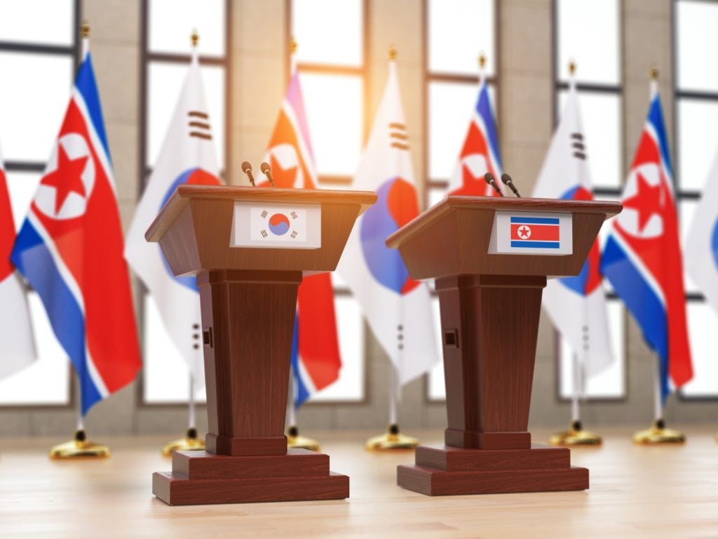 North and South Korean flags and tribunes at international meeting or press conference