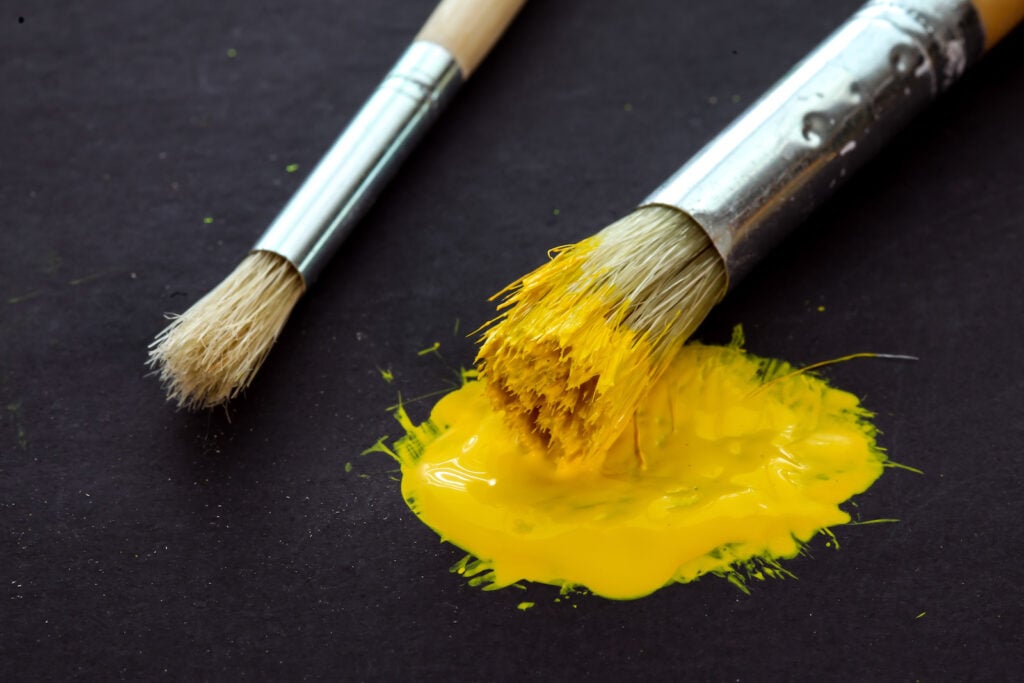 Yellow paint on brush and surface