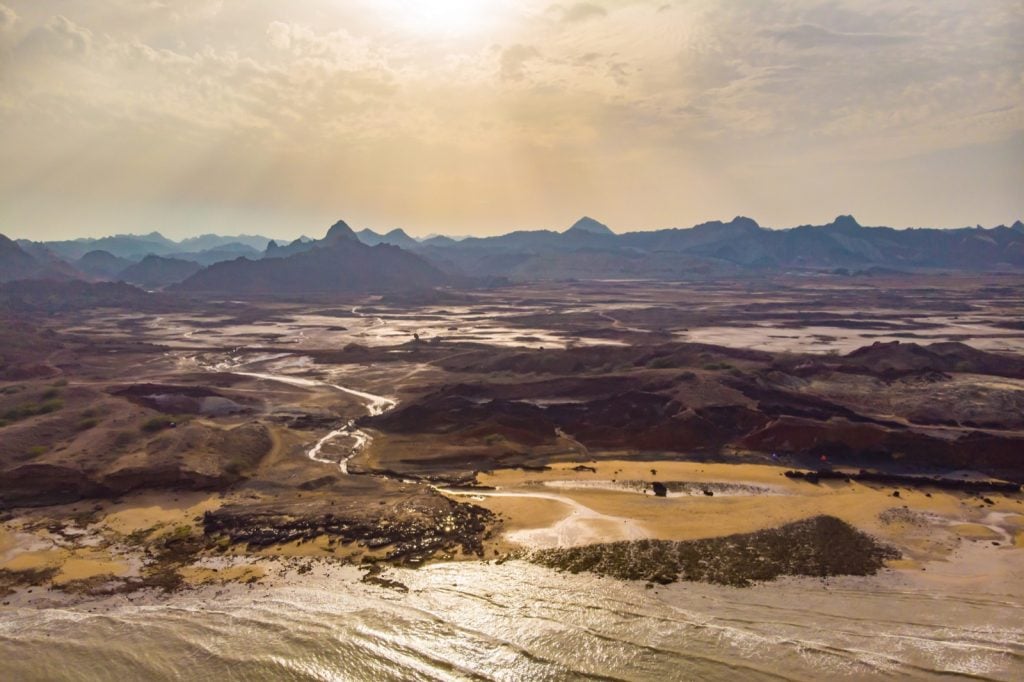 Aerial view of the colorful red mountains and yellow beach of Hormuz Island