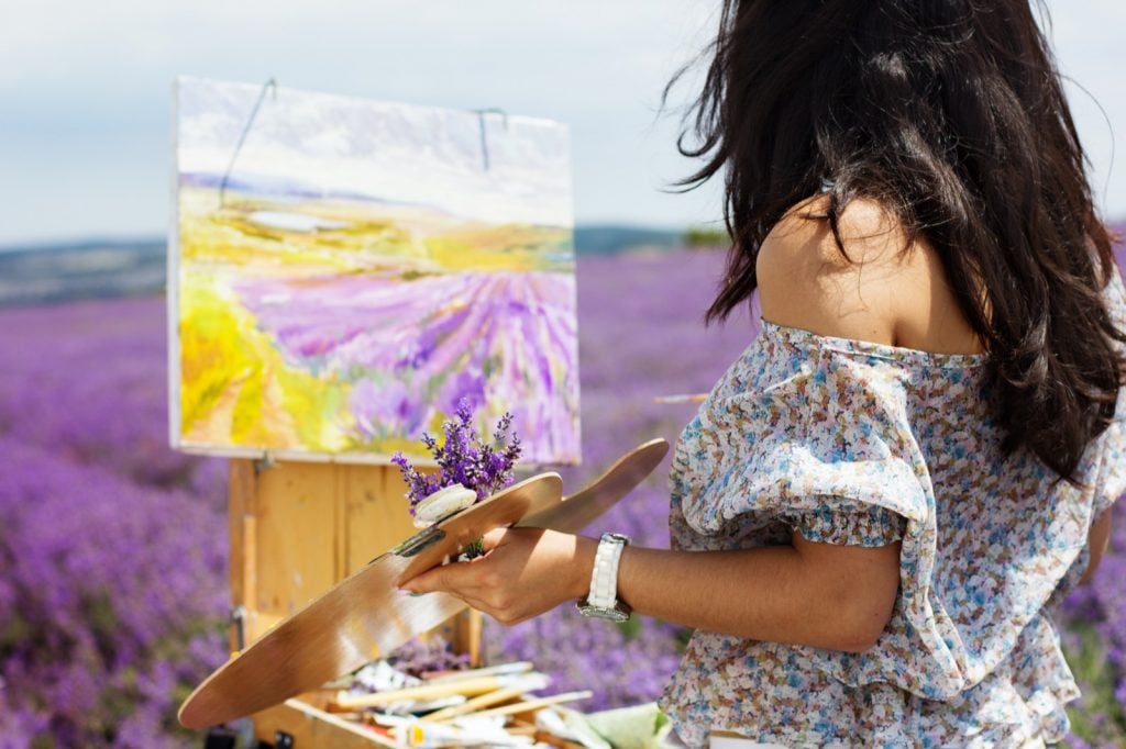 Female artist painting a purple lavender field