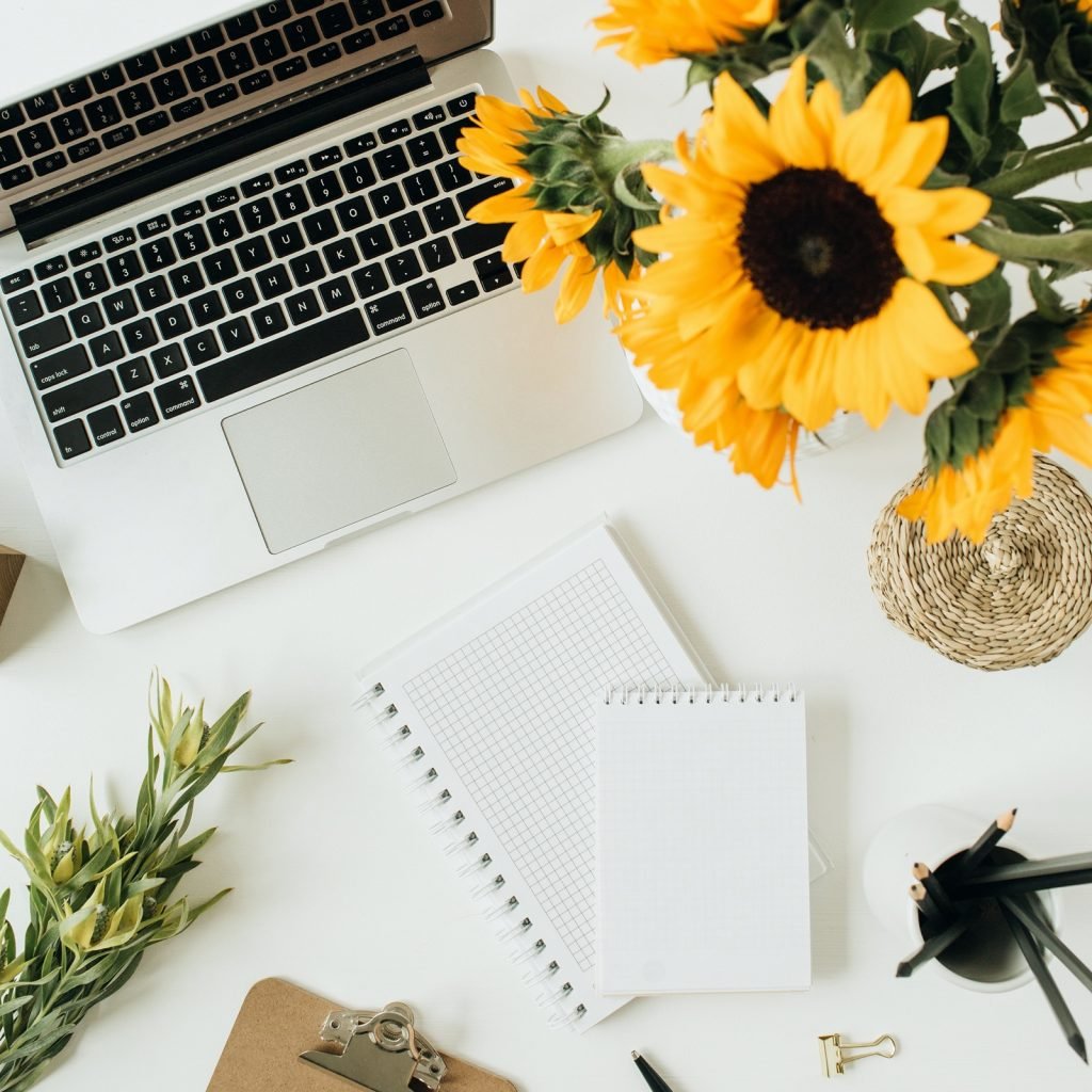 Bouquet of yellow sunflowers at office desk workspace
