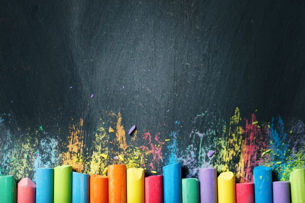Chalk in many different colors on a blackboard background