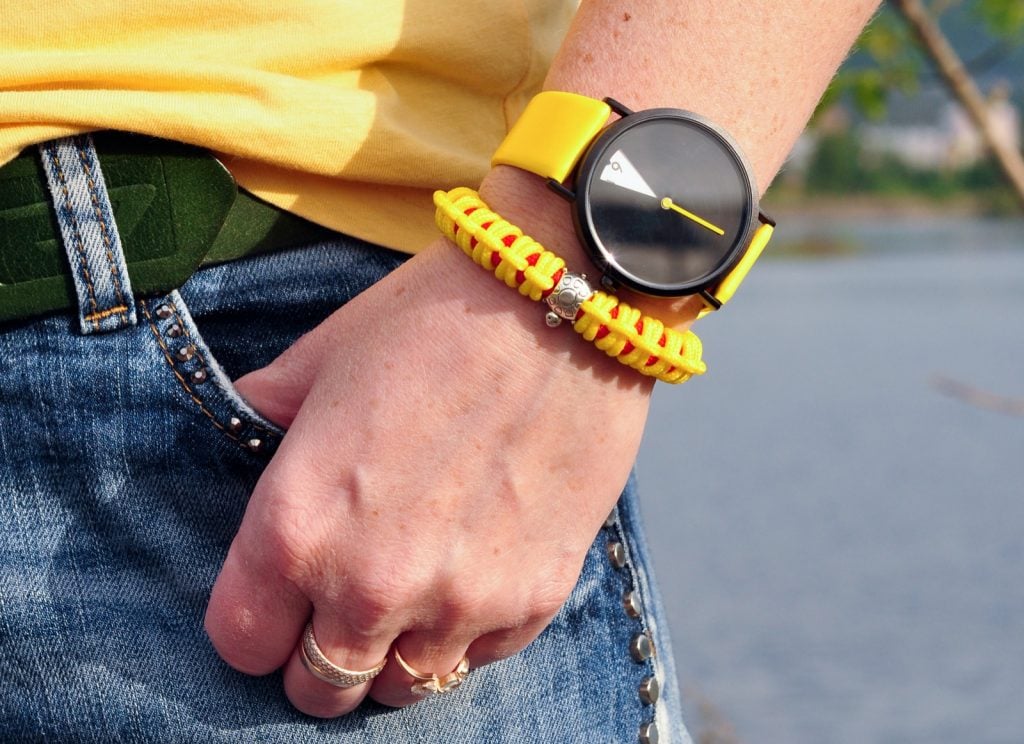 Gros plan d'une montre-bracelet jaune vif un jour d'été