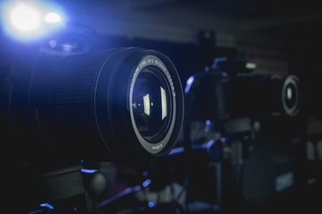 Closeup of a two camera setup and a spotlight in the background