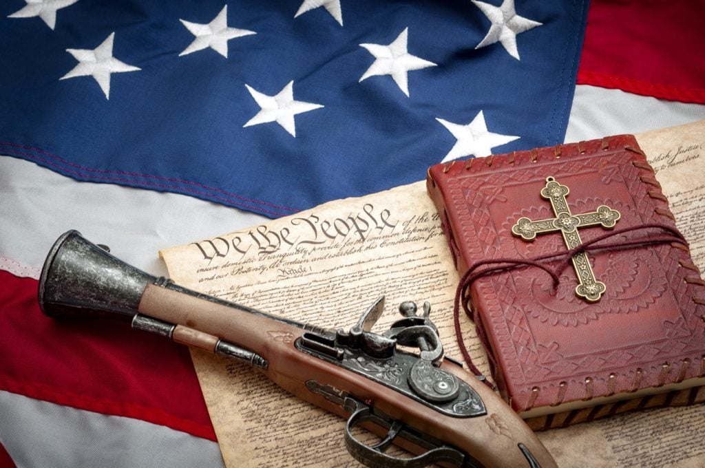 Blue red and white colored American flag with musket and bible