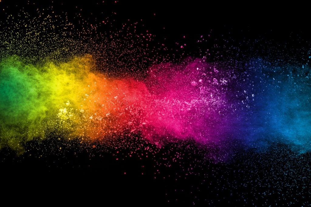 Colorful explosion of paint pigments on a black background