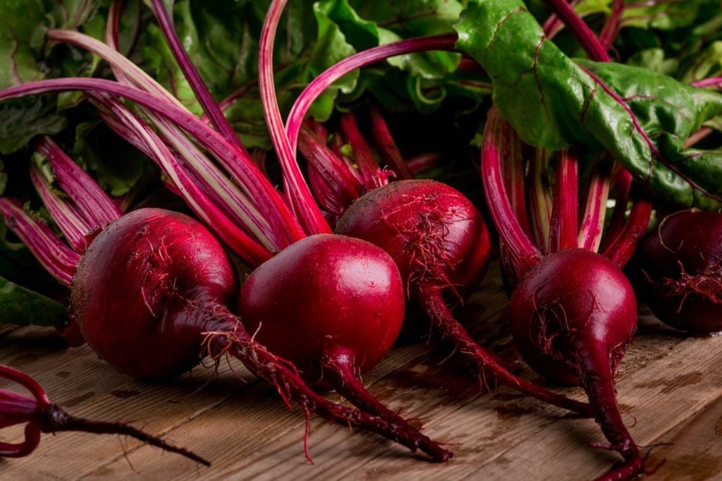 Dark red organic beetroot on wooden background