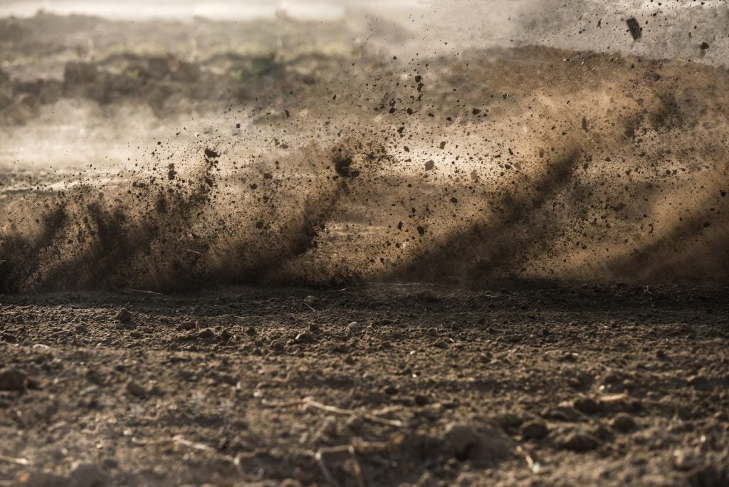 Dirt on the ground and in the air after motocross driving past at high speed