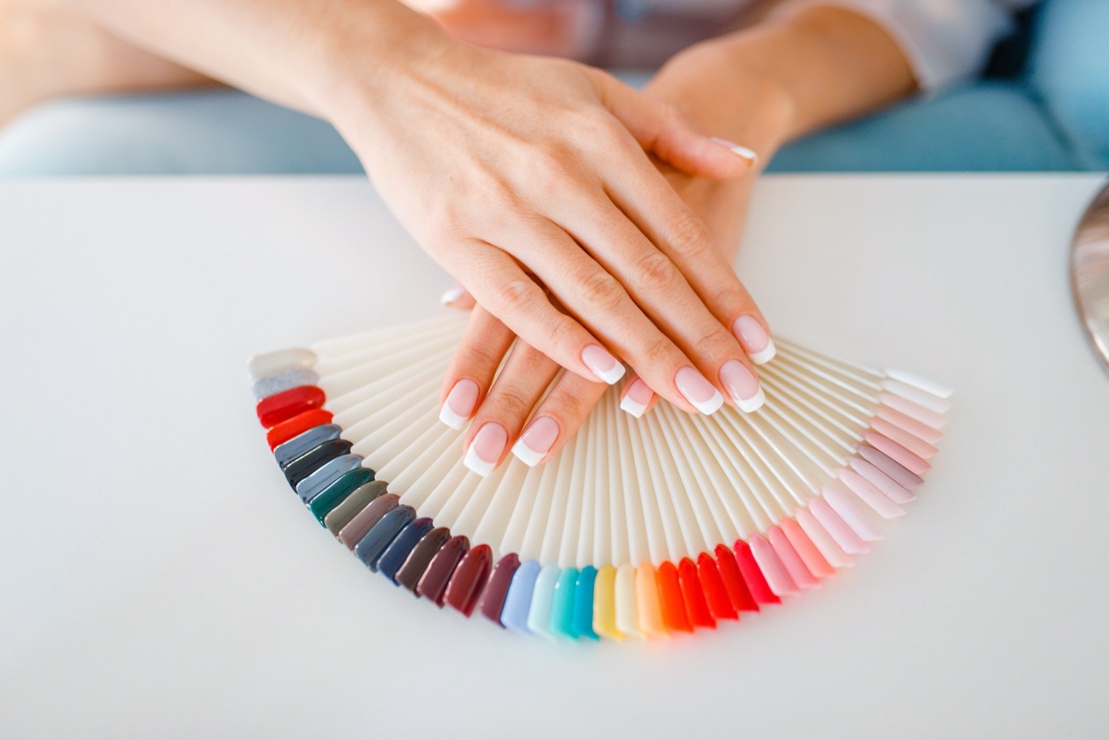 Colourful nail polish bottles on blue background, organic make-u Poster by  Anneleven Store - Pixels