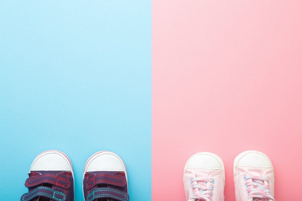 Pair of shoes on backgrounds with gender specific colors, blue for boys and pink for girls