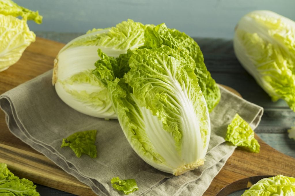 Raw Green Organic Napa Cabbage on wooden copping board