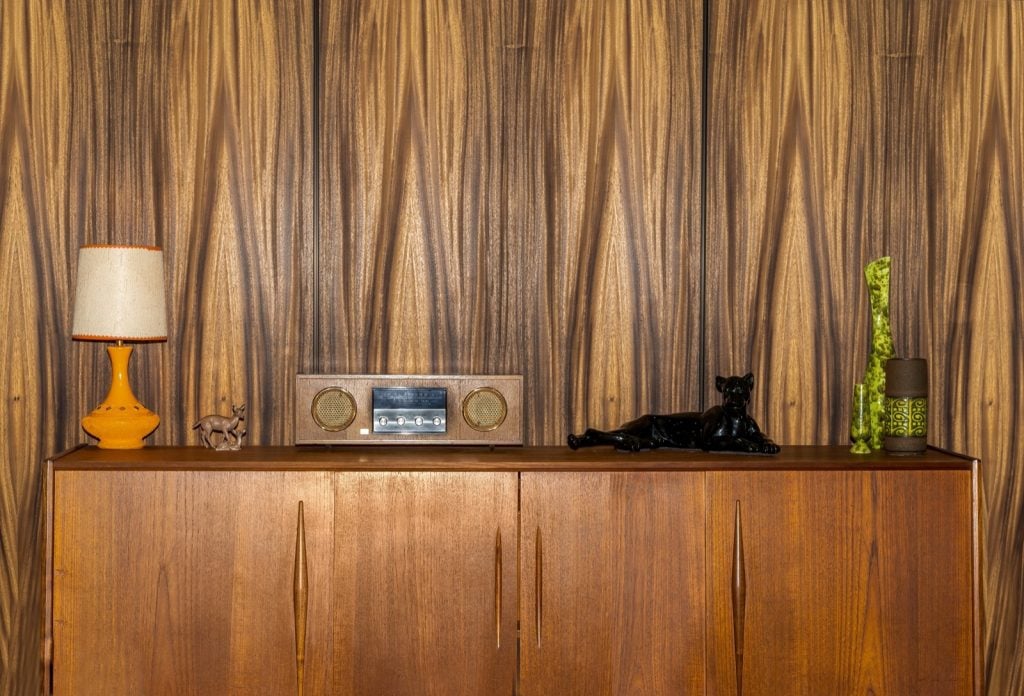 Retro 1970s teak cabinet in front of a brown wall