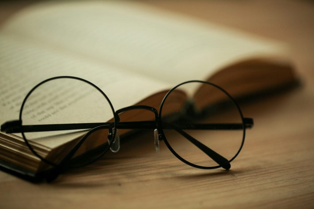 Black round glasses lying on book